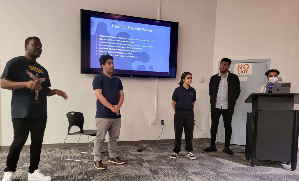 Crew members present their solution to mission control at the hackathon closing ceremony.