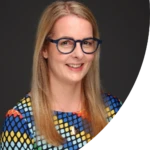 Di Mayze, a smiling woman with blonde hair and glasses.