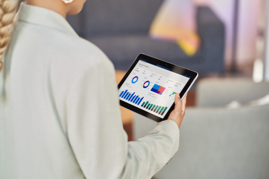 Retail store manager walking the store floor and analysing data on a tablet, powered by connected commerce.