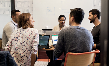 A team sits around a table at a meeting