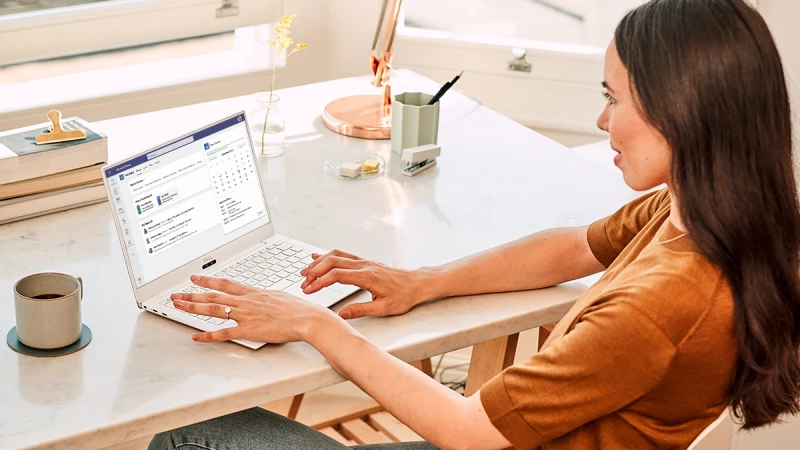 A person using a laptop with the Workday for Teams app displayed on the screen