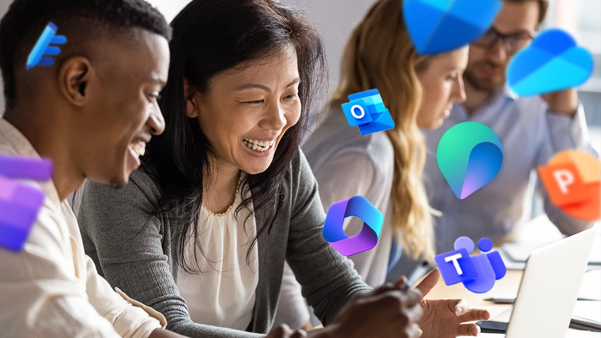 One woman and one man sitting and smiling at a computer, with Microsoft Teams and Copilot logos