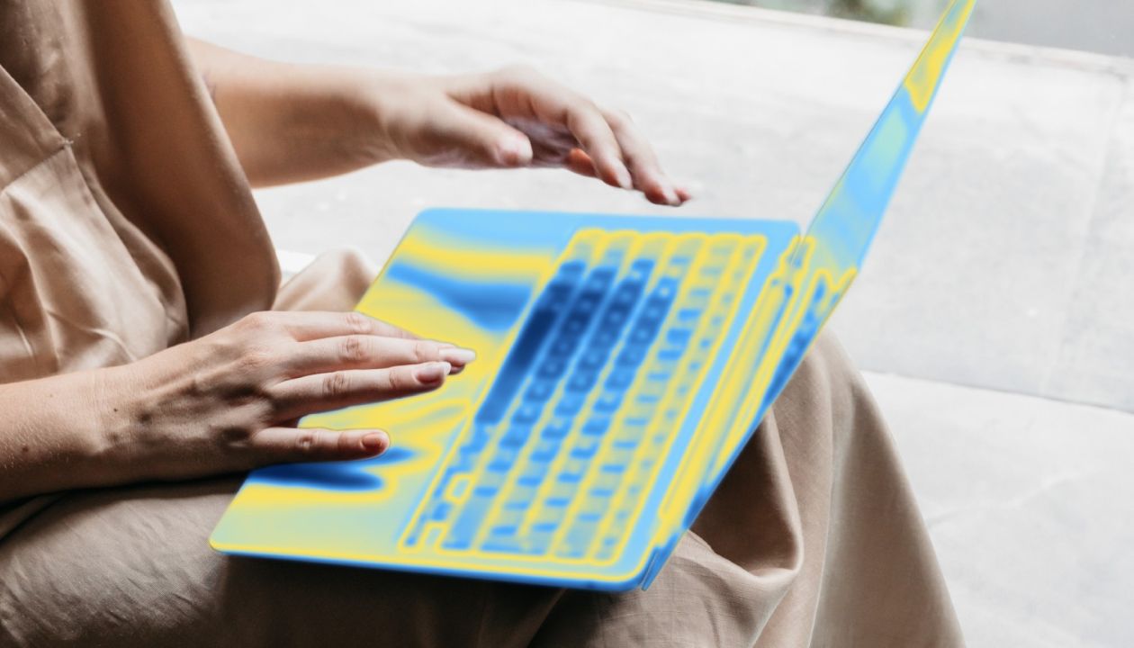 A person typing on a blue and yellow stylized laptop