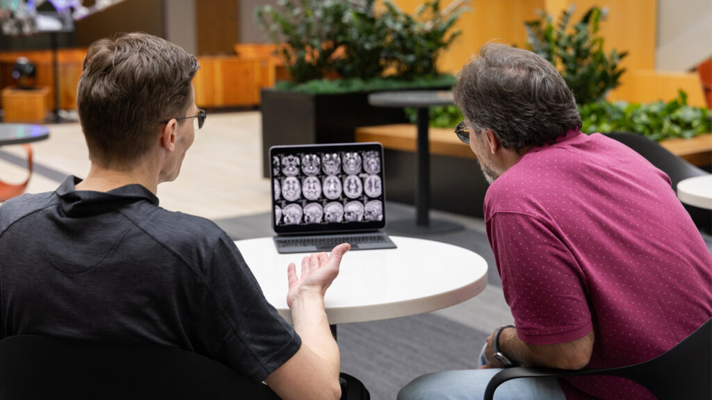 Tyger - portable MRI story: two people discussing MRI scans on a laptop