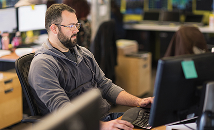 A tech worker stares at a computer monitor