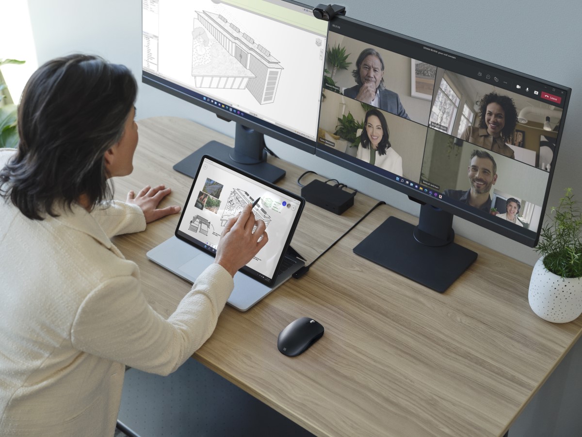Adult female is collaborating on a Microsoft Teams video call presented on the right monitor, while Revit is in use on the left