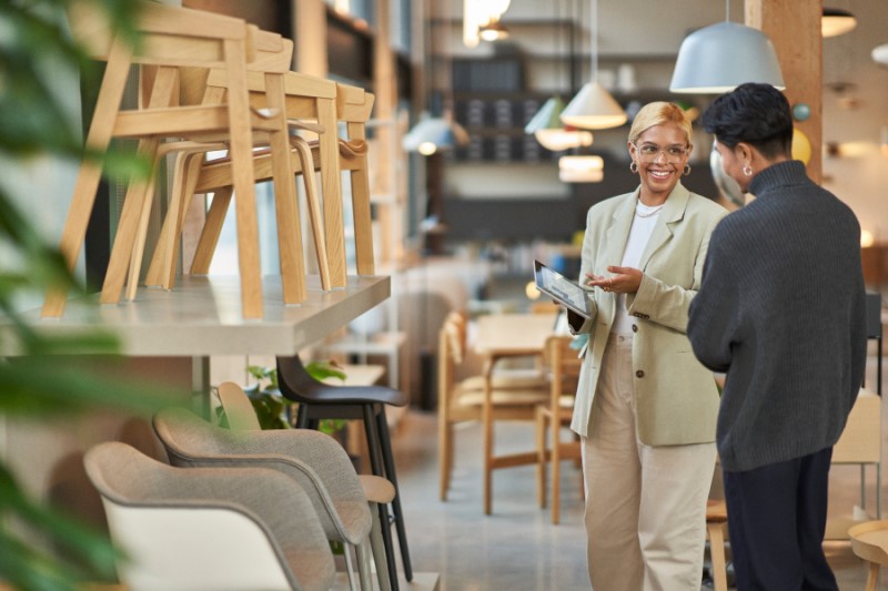Retail store manager working with a customer, showing merchandise and providing customer service on-the-go using a tablet to locate inventory and place orders