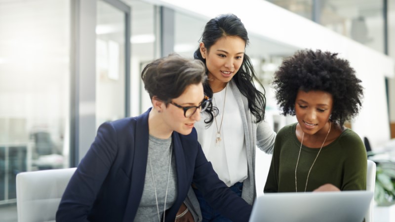 Shot of a group of businesswomen using a laptop during a meeting at work