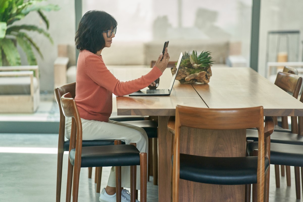 Business decision maker using multifactor authentication on a mobile phone before working from home on a laptop