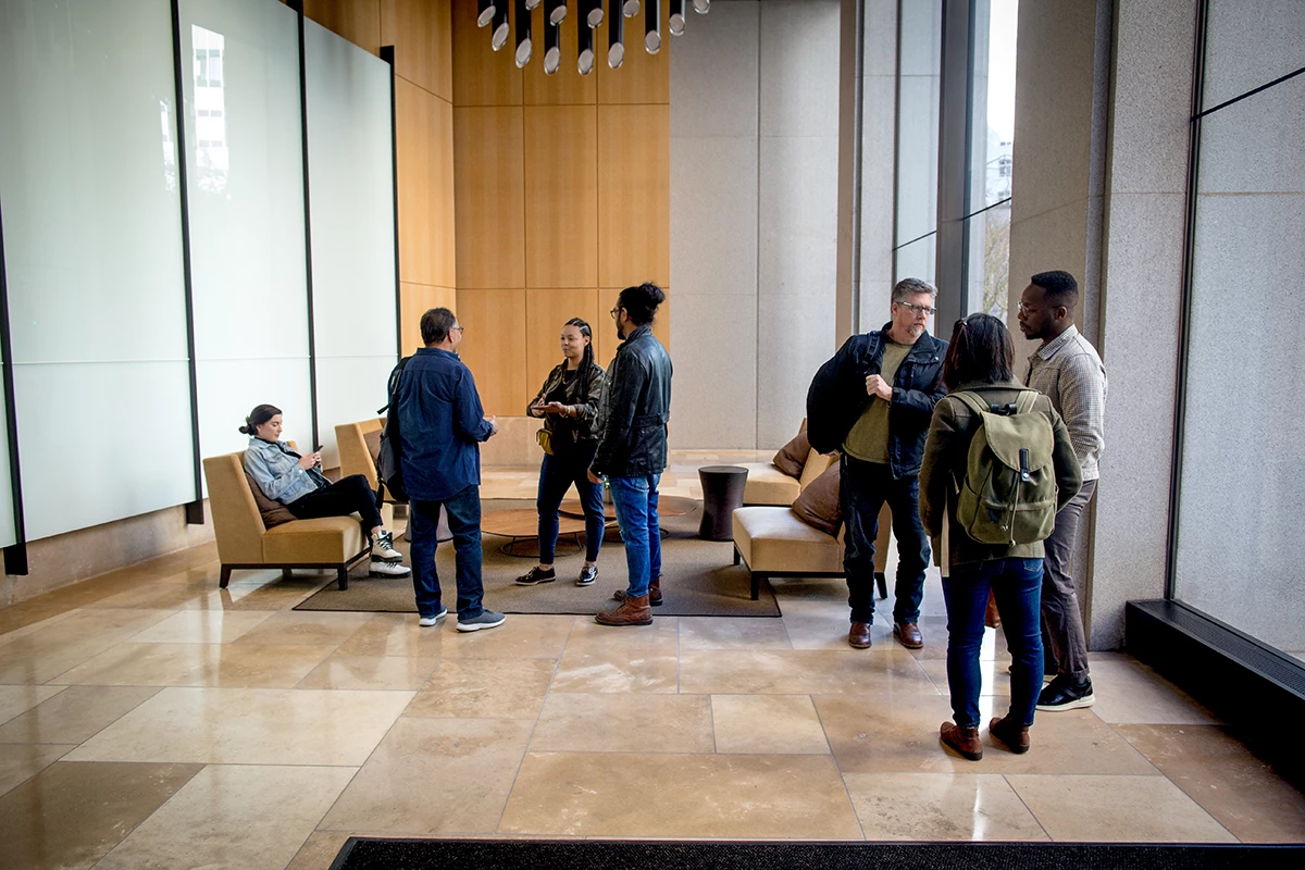Developers on-the-go, meeting up in the lobby. Male and female developers collaborating outside the office