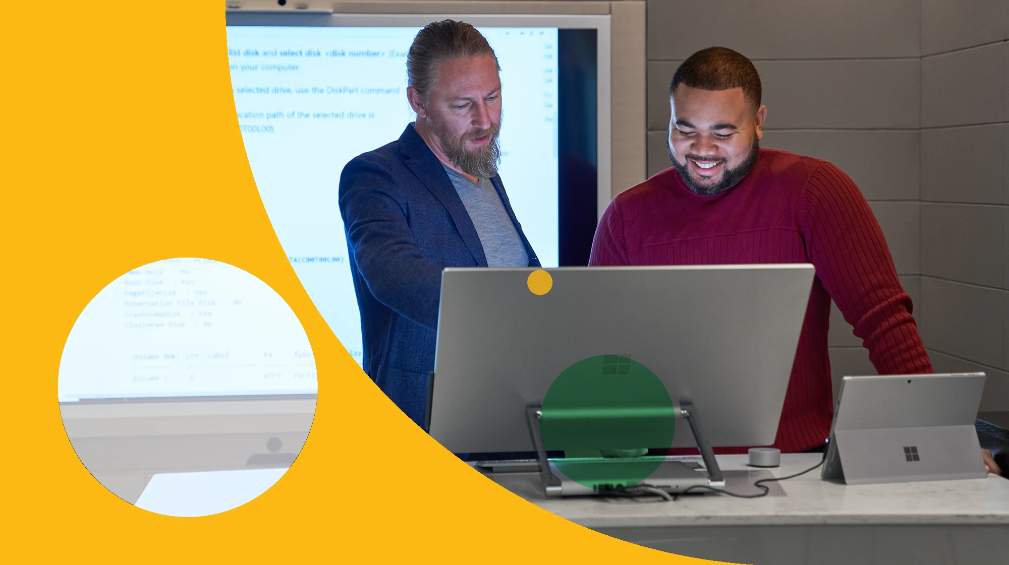 Forward facing view of two men working on a Microsoft Surface Studio with a larger blurred screen/display behind them