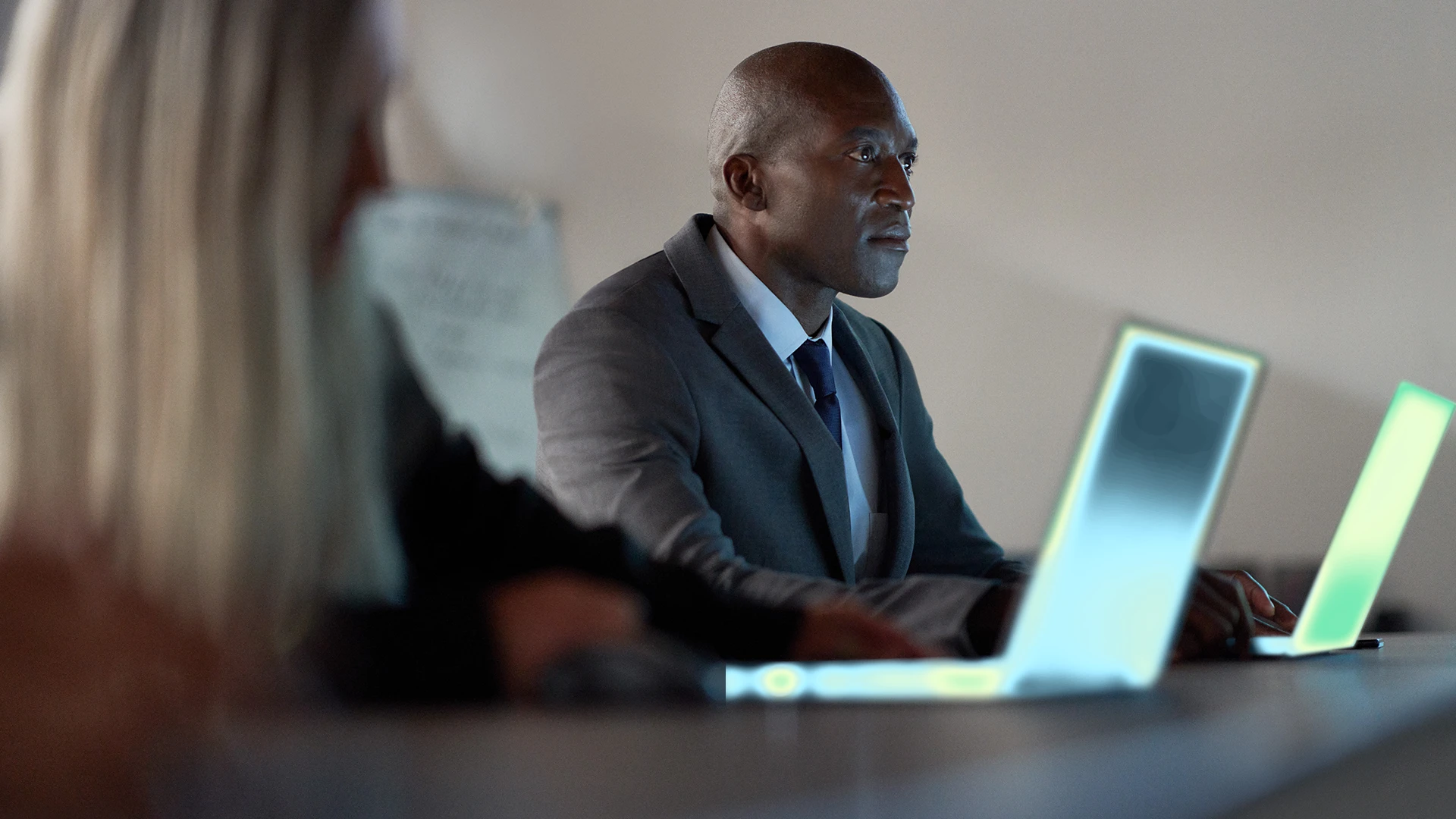A man in a suit and tie looking at a laptop