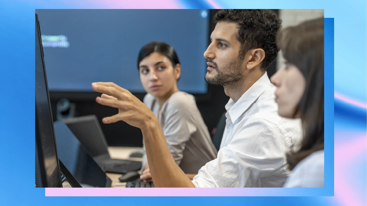 Three people sit at computers in a security operations center