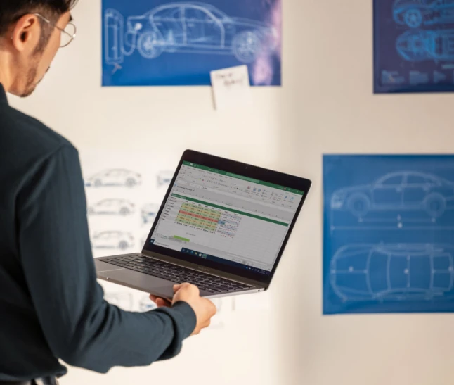 Man looking at laptop in front of brainstorming wall