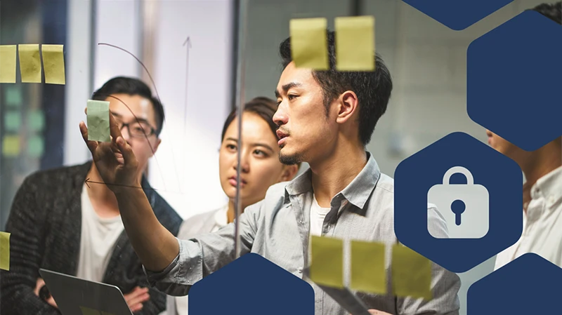 Photo of people brainstorming with multiple post its in a glass wall